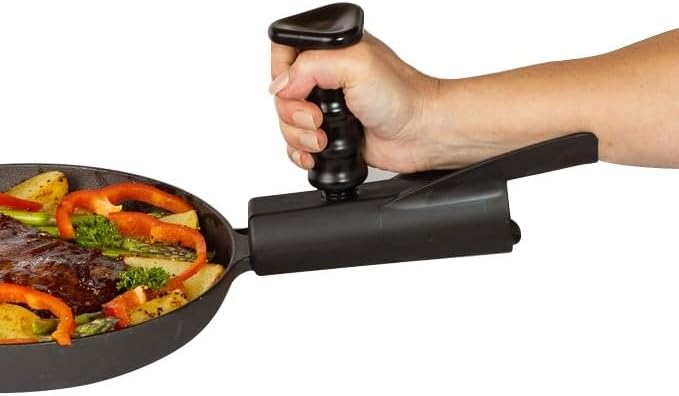 A hand lifts a pan with a black pan buddy, which creates an extended vertical handle and under-support.