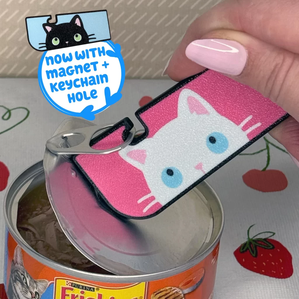 A hand with pink nails opens a can of cat food with a large tab buddy that has a little white cat face on it.