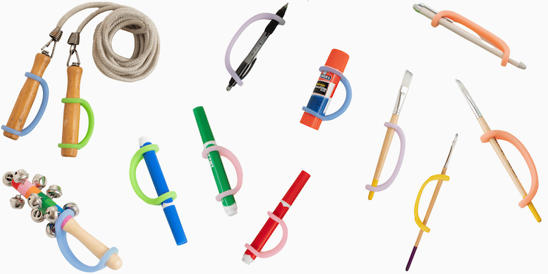 Various tools and toys for learning and play such as markers, paintbrushes, and jump ropes with EasyHold universal cuffs on them to create a handle. Over a white background.
