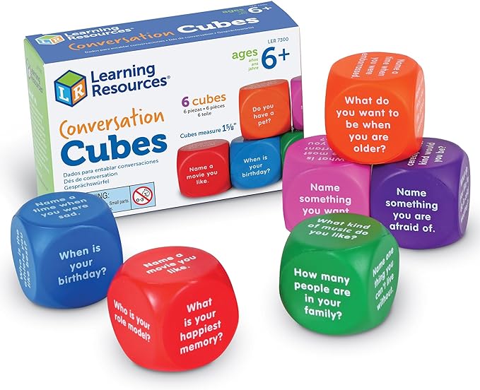 A box package and six foam cubes with question prompts on every side sit on a white background. 