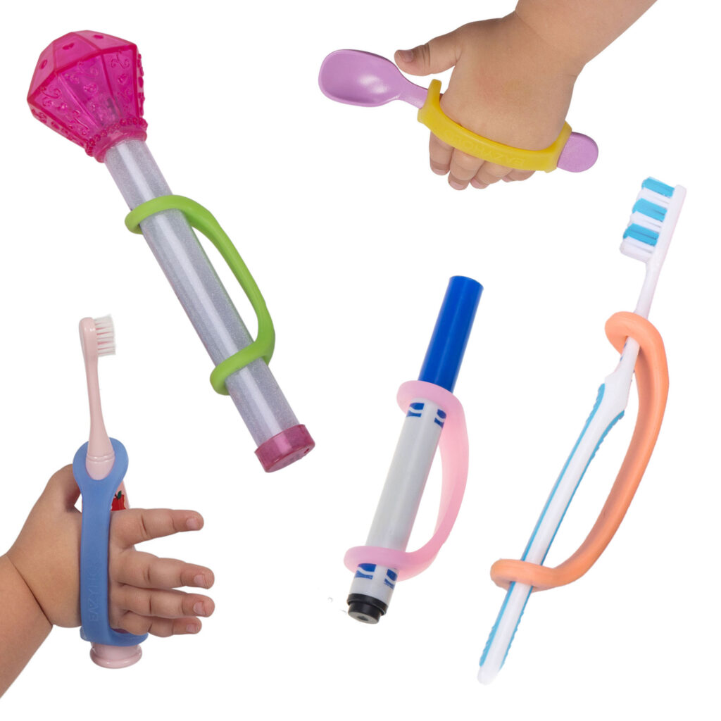 Five different sizes and colors of EasyHold universal cuffs on various tools for children, including an electric toothbrush, a toy wand, a pink spoon, a blue marker, and a regular toothbrush.